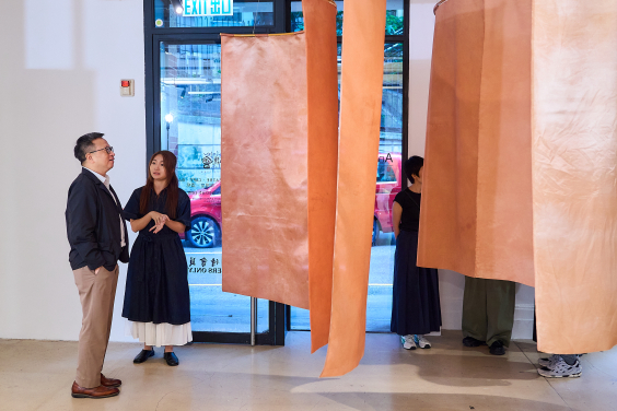 An exhibiting artist introduces their work to guests.